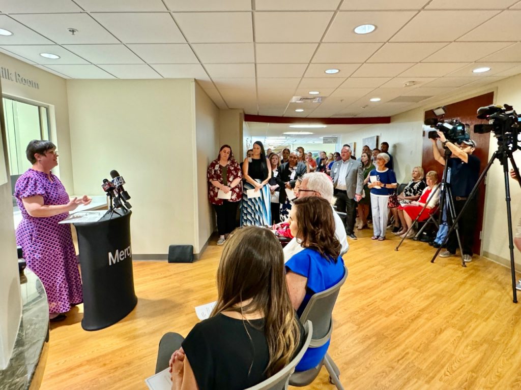A nurse speaking to a crowd of people in front of the Braum's Infant Milk Room